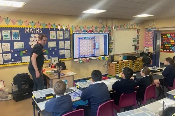 Instructor teaching circuit theory with a diagram on screen while students work with Snap Circuits kits
