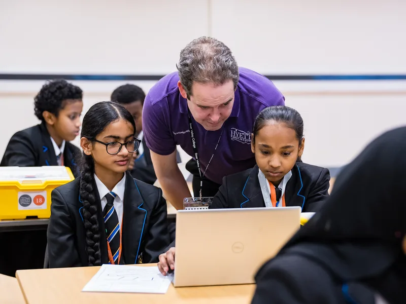STEM instructor guiding students through a hands-on robotics activity
