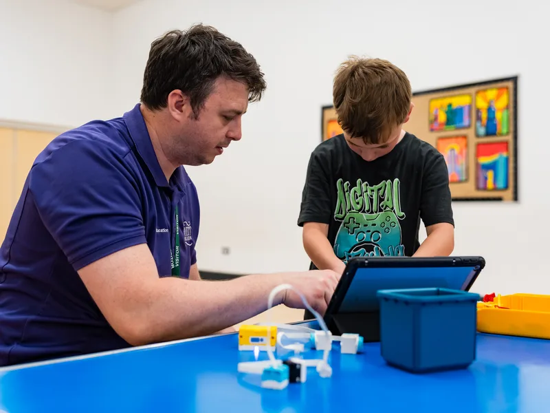 Child proudly showing their STEM project