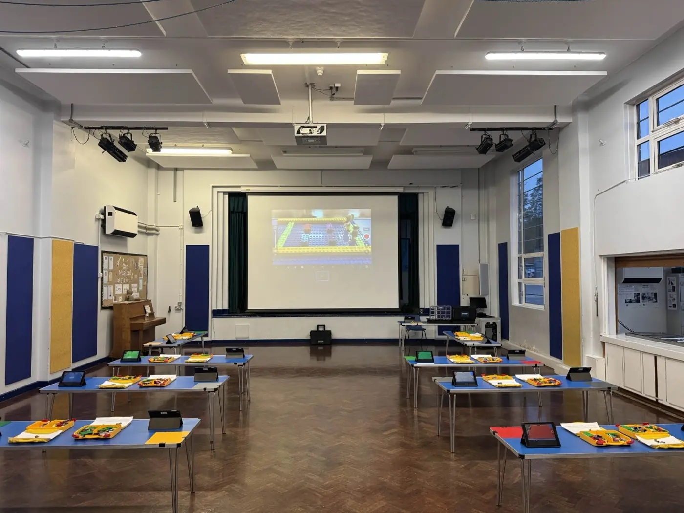A school hall set up for stop-motion animation, with trestle tables in pairs and tablets at each station