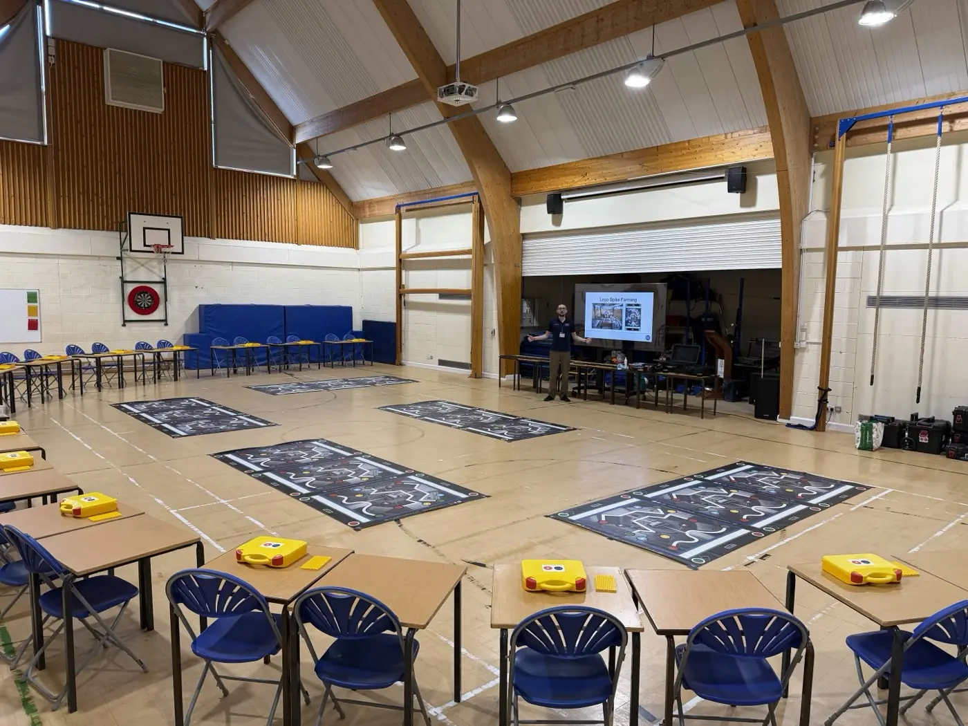 A school hall set up for Intermediate STEMbotics with exam tables in rows and a clear central activity area for robotics challenges