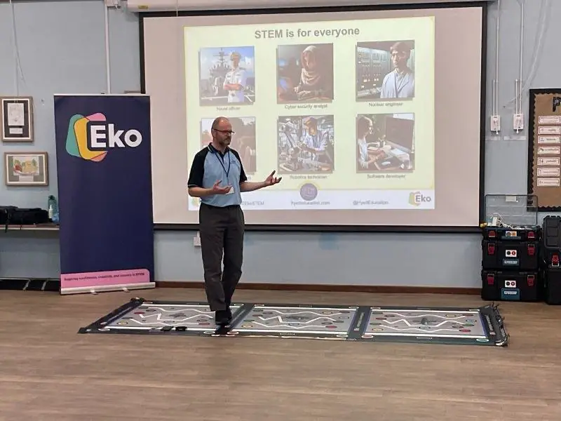 An RAF STEM Ambassador giving pupils a careers briefing in front of an EKO banner