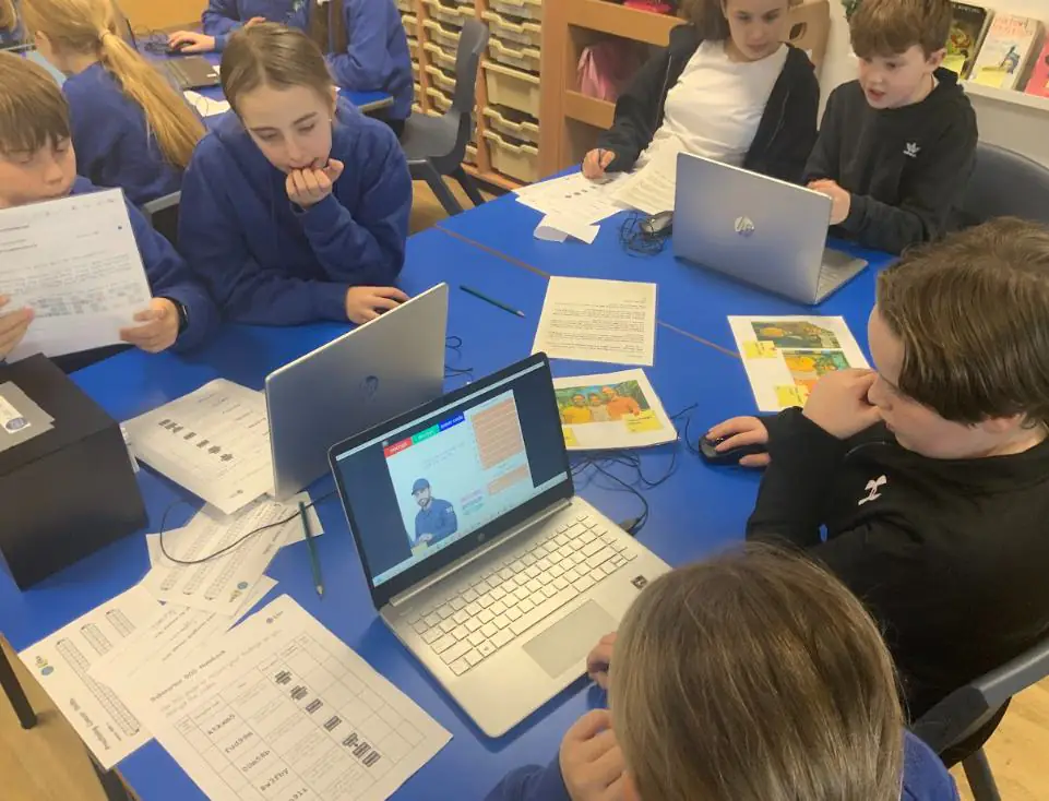 Year 6 students at a laptop working on the cybersecurity challenge