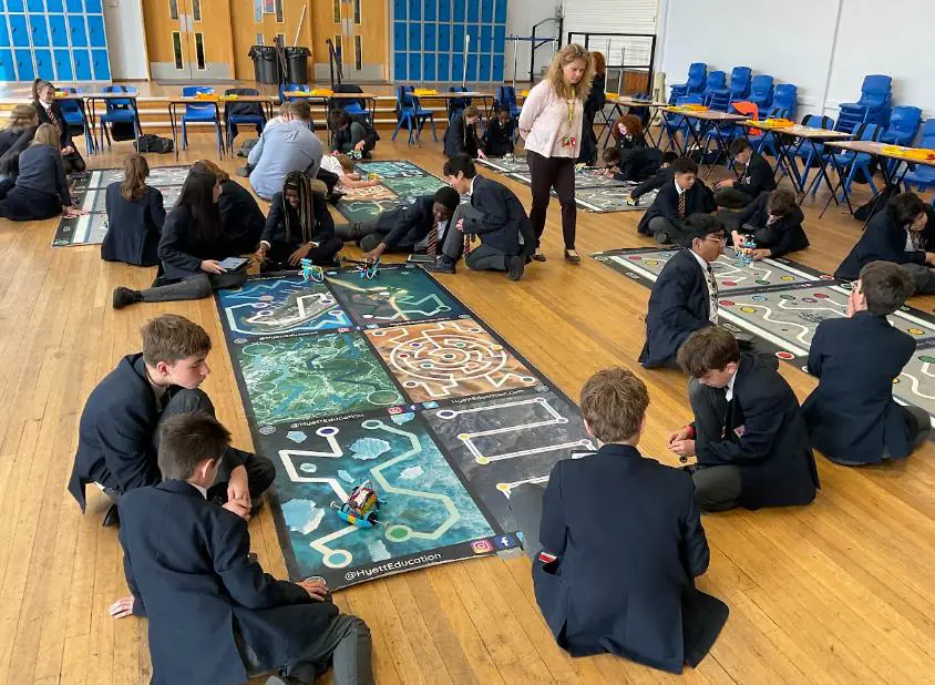 Secondary students competing with robots on challenge mats