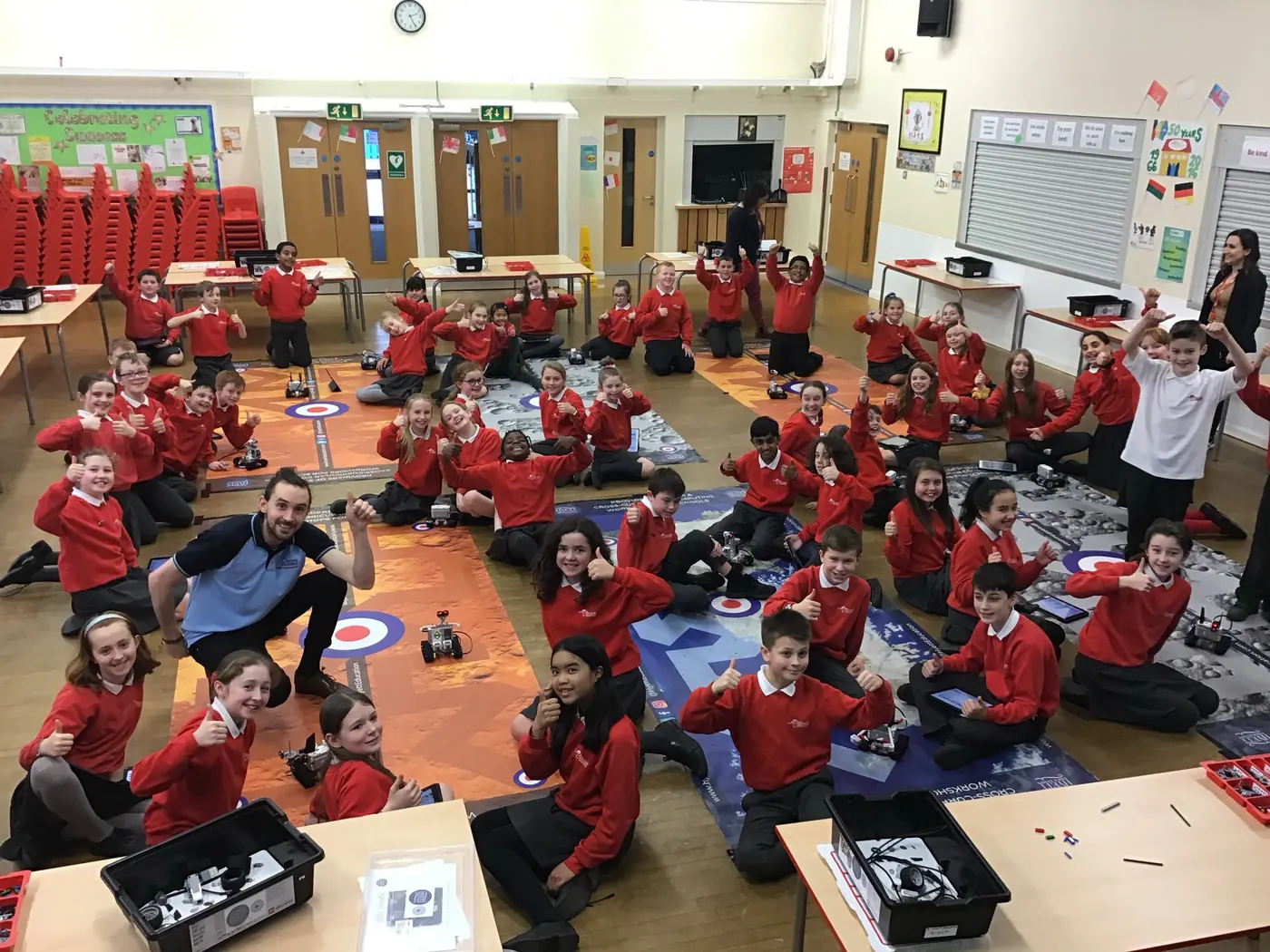 A class of primary pupils with their robots on challenge mats