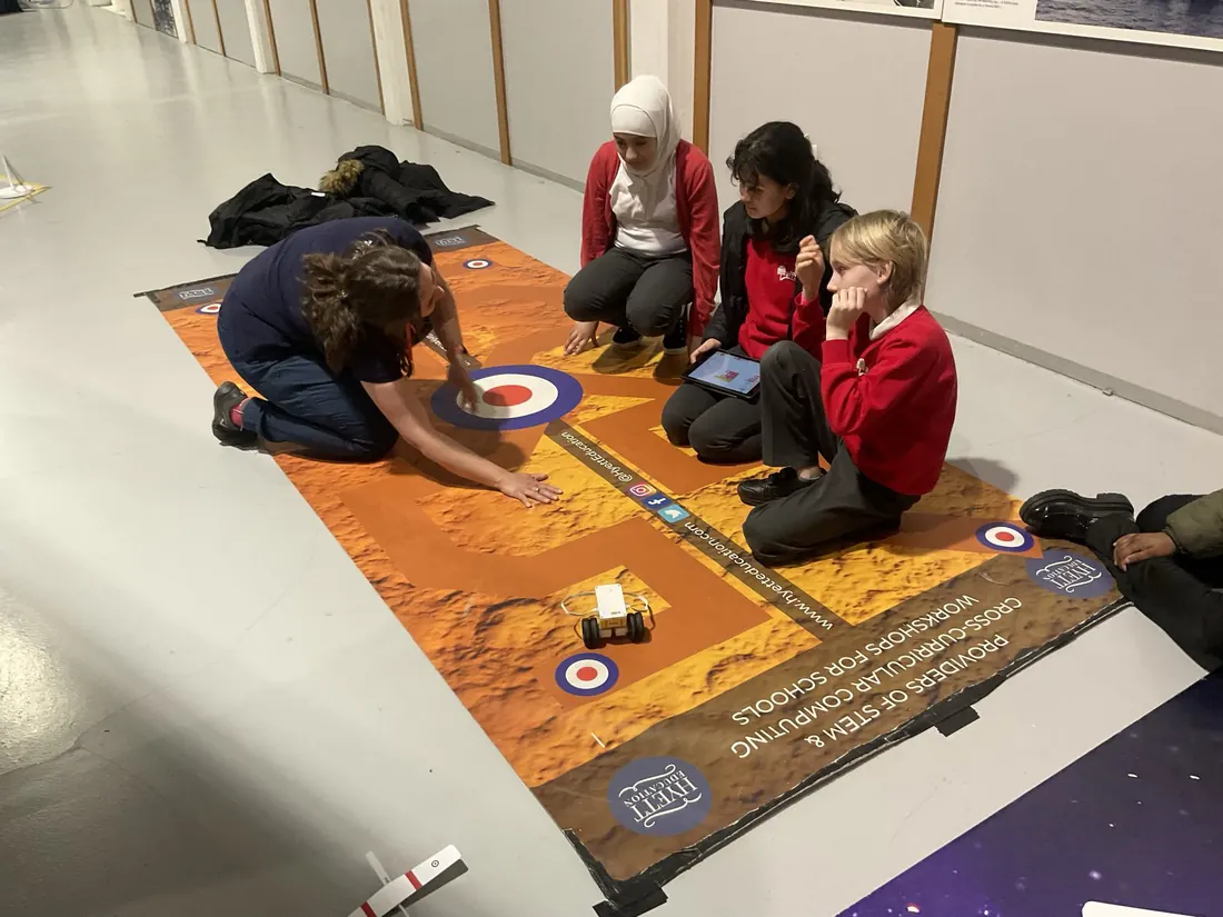 Pupils coding a robot on a challenge mat at Forces in STEM