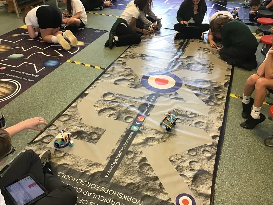 Pupils coding robots on a lunar challenge mat