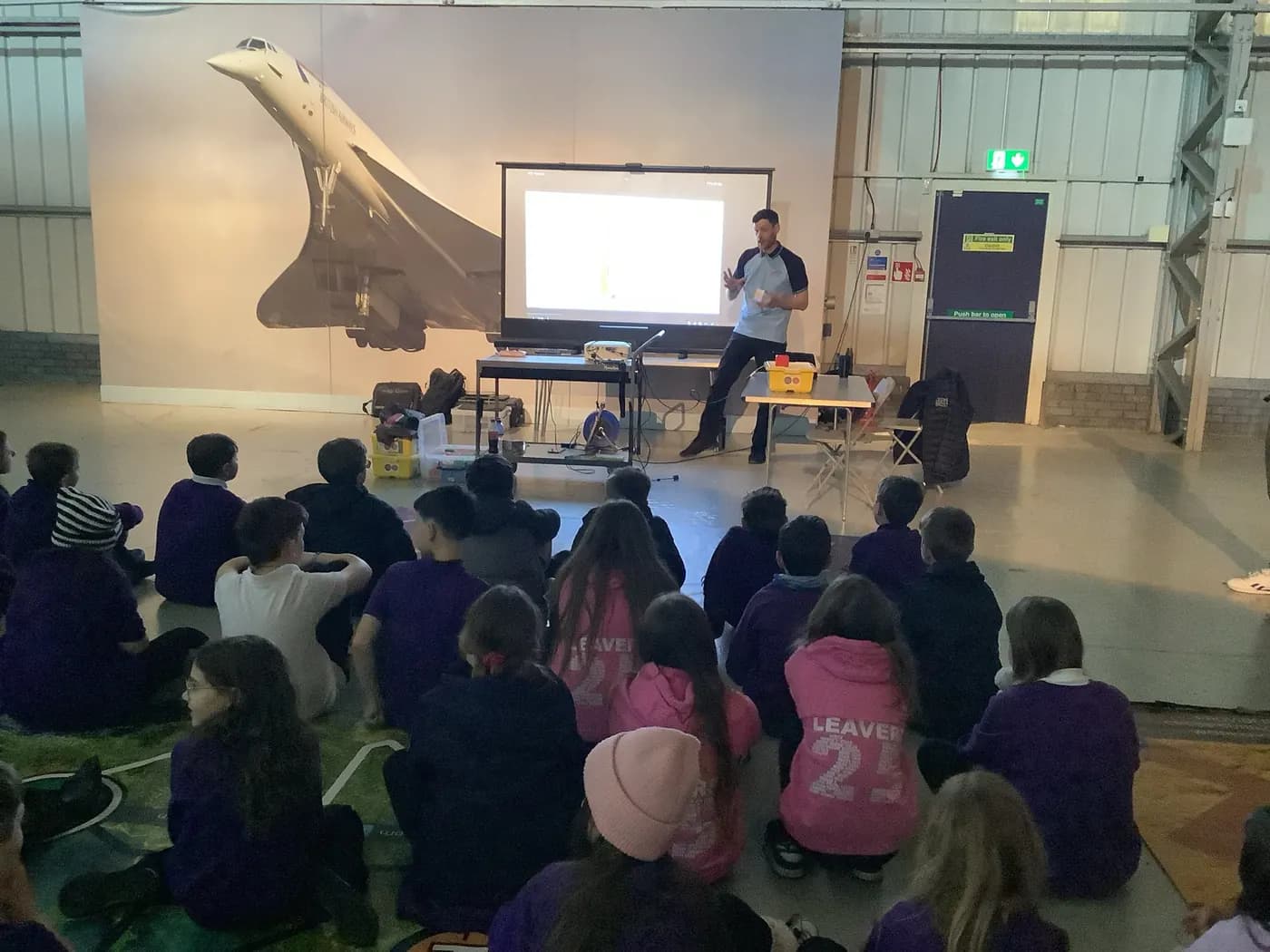 Young people at a talk beneath Concorde at the National Museum of Flight
