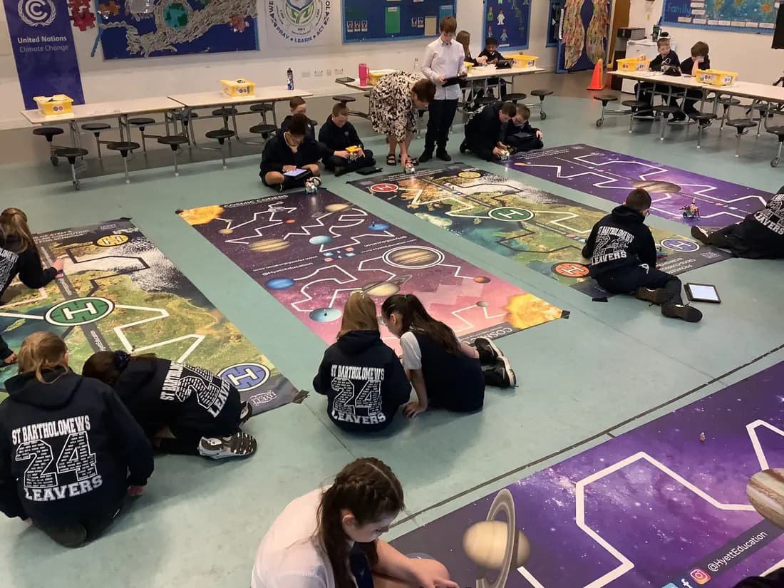 Pupils coding robots on themed floor mats