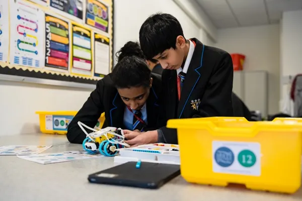 Two secondary students building a LEGO SPIKE Prime robot during an intermediate robotics workshop