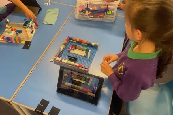 A child building a LEGO scene with the stop-motion animation app visible on an iPad