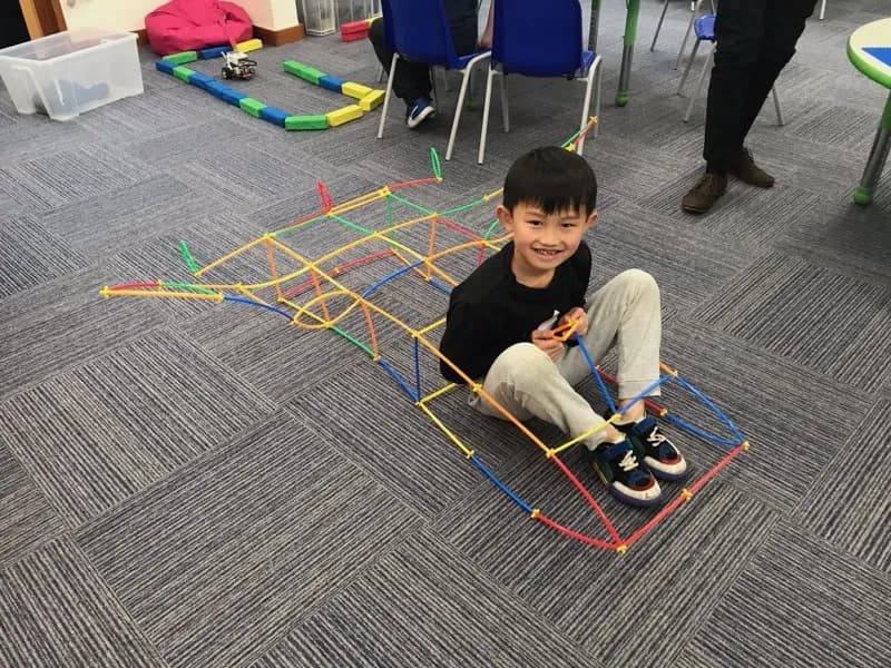 Boy building a structure from straws and connectors at a Tech Tigers holiday club