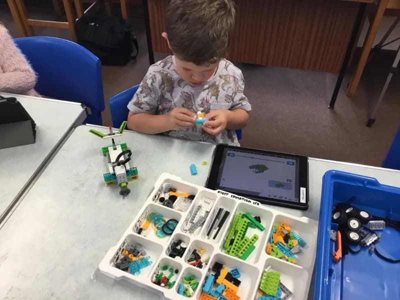 Boy building a robot with a LEGO WeDo kit