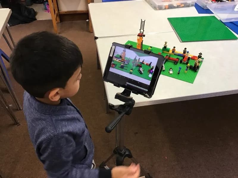 Boy creating a stop-motion animation with an iPad and LEGO scene