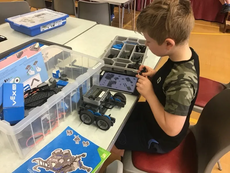 Boy building a VEX robot at a Tech Tigers session